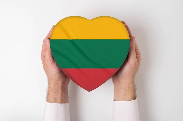 Σημαία της Λιθουανίας σε ένα κουτί σε σχήμα καρδιάς σε αρσενικά χέρια. Λευκό φόντο — Φωτογραφία Αρχείου