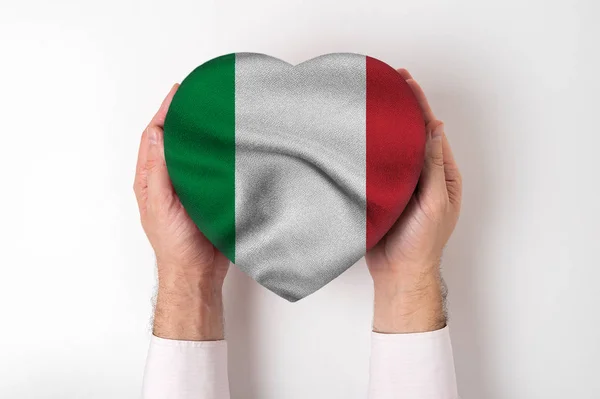 Olaszország zászlója egy szív alakú dobozon, férfi kezekben. Fehér háttér — Stock Fotó