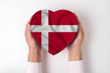 Erkek elinde kalp şeklinde bir kutuda Danimarka bayrağı. Beyaz arkaplan