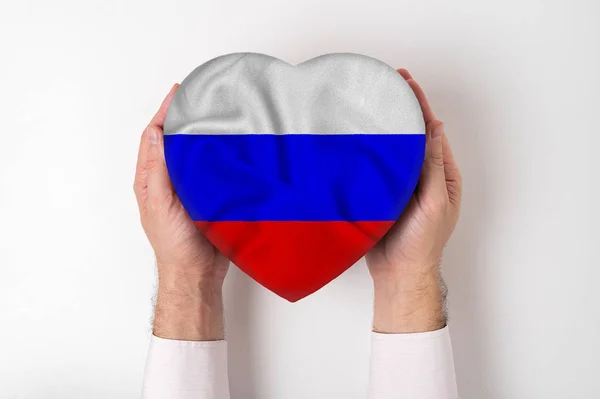 Bandeira da Rússia em uma caixa em forma de coração em mãos masculinas. Fundo branco — Fotografia de Stock