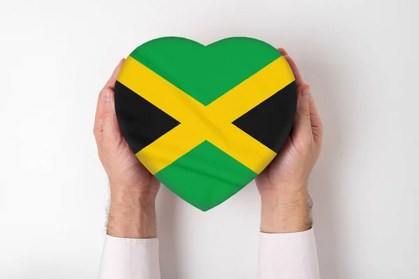 Bandera de Jamaica en una caja en forma de corazón en manos masculinas. Fondo blanco — Foto de Stock