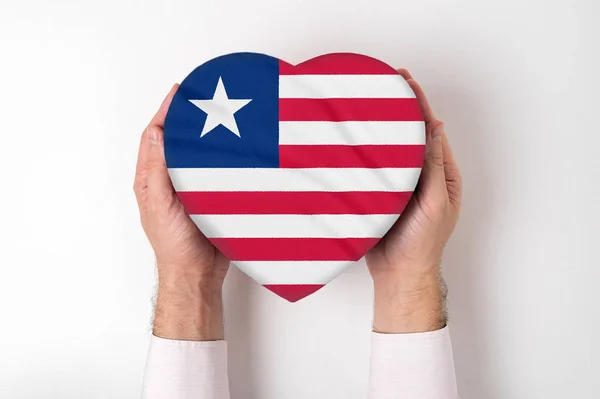 Flag of Liberia on a heart shaped box in a male hands. White background — Stock Photo, Image