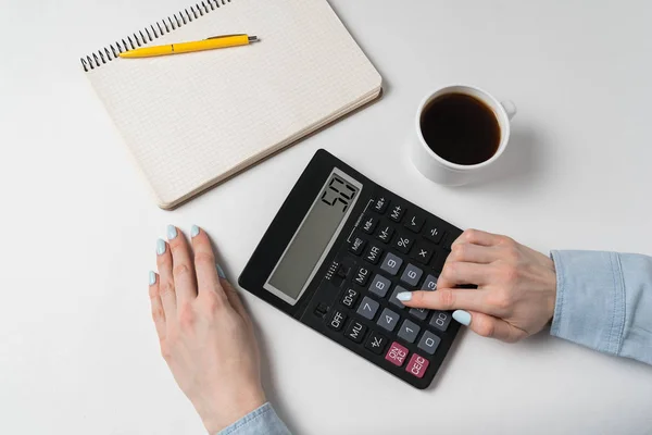 Mão de mulher jovem usando calculadora. Conceito de planeamento orçamental. Fundo branco, vista superior — Fotografia de Stock