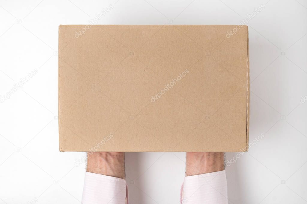 Rectangular box on men's hands on white background. Directly above, mock up