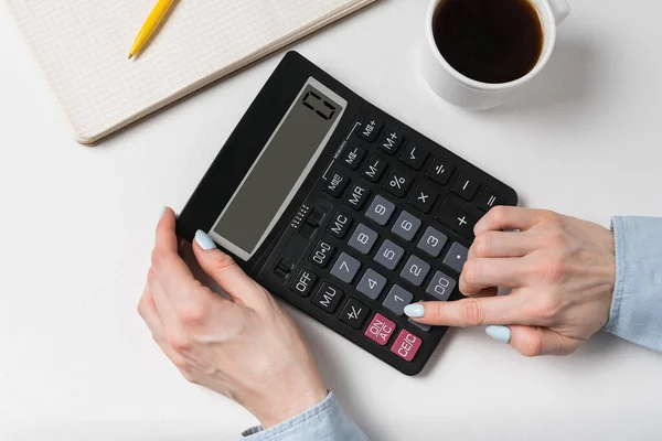 Mulher usando calculadora. Documentos, xícara de café e calculadora sobre um fundo branco. Vista superior — Fotografia de Stock