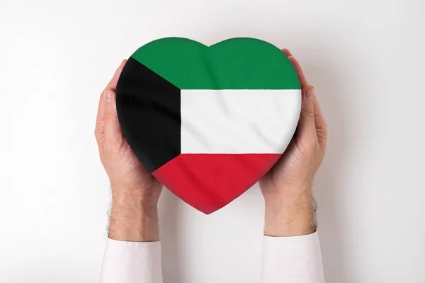 Bandera de Kuwait en una caja en forma de corazón en manos masculinas. Fondo blanco — Foto de Stock
