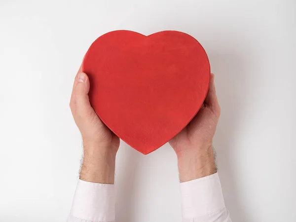 Caja en forma de corazón rojo de estilo vintage en manos masculinas aisladas sobre fondo blanco — Foto de Stock