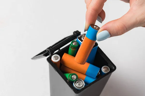 Жіноча рука кидає використаний акумулятор у смітник. Концепція збору та переробки використовуваних батарей . — стокове фото