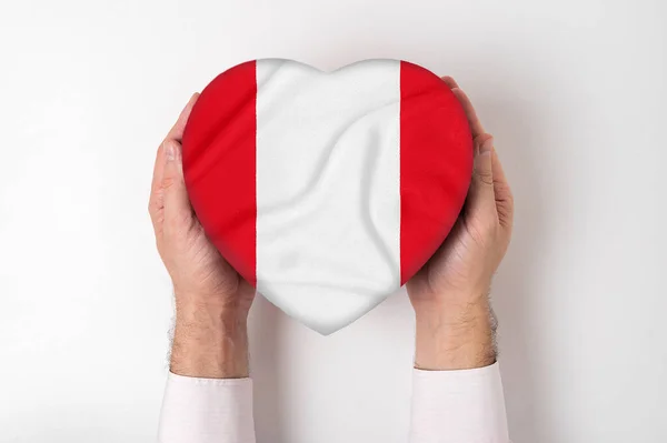 Bandeira do Peru em uma caixa em forma de coração em mãos masculinas. Fundo branco — Fotografia de Stock
