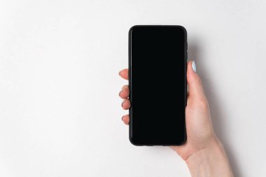 Beyaz arka planda akıllı telefonu tutan bir kadın. Boş ekran. Boşluğu kopyala