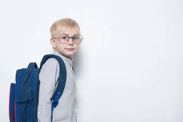 Colegial con gafas y mochila sobre fondo blanco. Escuela Primaria. Copiar espacio —  Fotos de Stock