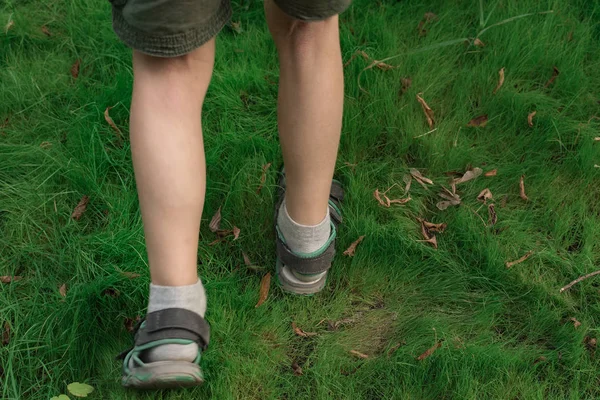 El chico camina por la hierba. Pies en el césped de fondo . — Foto de Stock