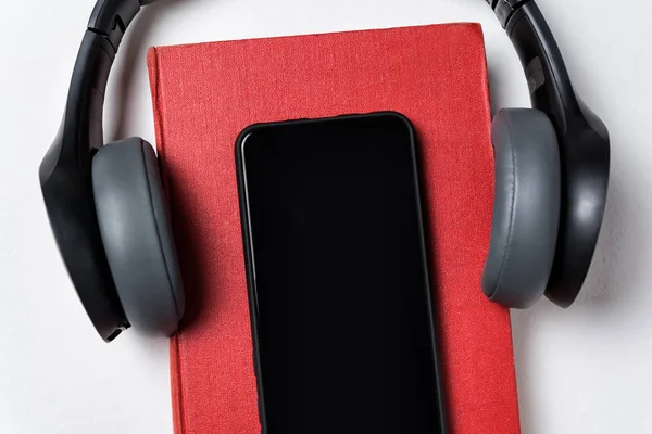 Auriculares, libro y teléfono celular sobre fondo blanco. Concepto de libro o audiolibro. Copiar espacio, Primer plano —  Fotos de Stock