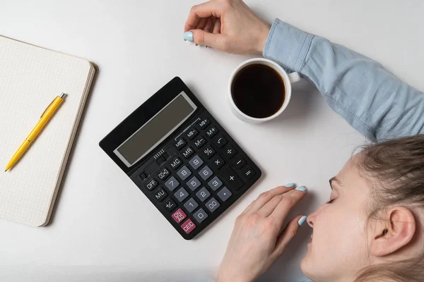 A mulher adormeceu ao lado da calculadora e do livro. Planejamento do orçamento, relatório escrito. Vista superior — Fotografia de Stock