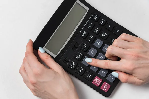 Mulheres mão e calculadora em um fundo branco. Conceito de planeamento orçamental — Fotografia de Stock