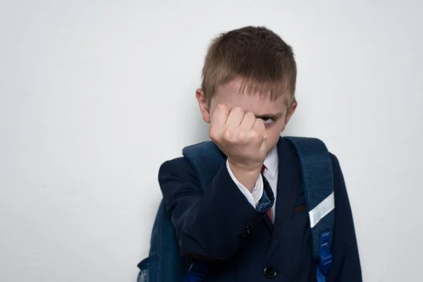 Schoolboy threatens with his fist. Boy in school uniform. White background. Brawler — Stock Photo, Image