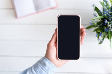 Arka planda akıllı telefon tutan bir kadın. Siyah boş ekran. Boşluğu kopyala
