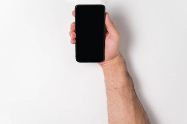 Beyaz arka planda akıllı telefonu tutan bir adam. Boş ekran. Boşluğu kopyala