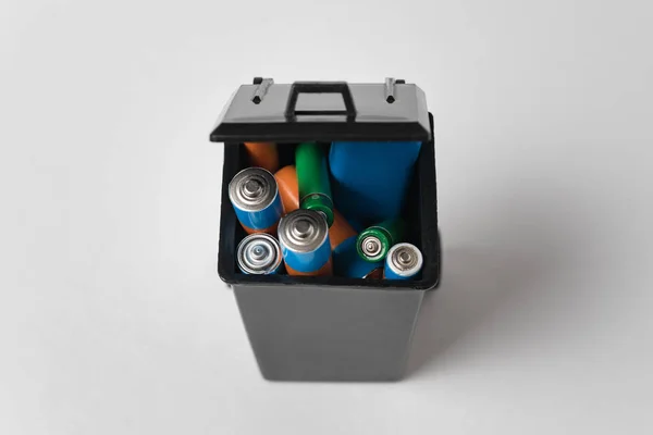 Baterías en contenedor de basura sobre fondo blanco. Eliminación adecuada de las pilas tóxicas para el medio ambiente y el suelo . —  Fotos de Stock