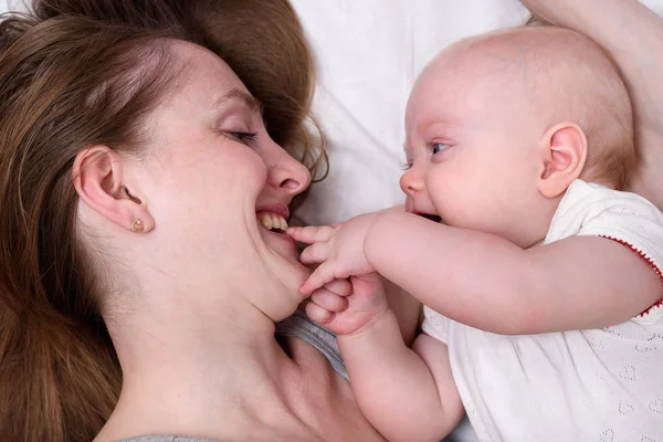 Glücklich lächelnde junge Mutter mit kleinem Baby. Nahaufnahme Porträt. Mutterschaftskonzept — Stockfoto