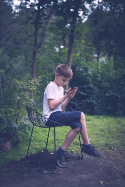 Gençlerin cep telefonu mesajları doğa arka planına göre sıralanır. Dikey çerçeve.