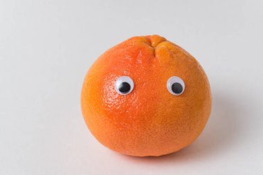 Komik Yüzlü Yemek. Beyaz arka planda turuncu meyve karakteri. yaratıcı fikir