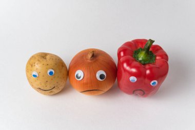Patates, soğan ve komik yüzlü biber. Beyaz arkaplan üst görünümü. konsept diğerlerinden farklı..