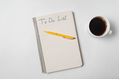 Notepad 'da listeleme yapmak için. Not defteri, kalem ve kahve beyaz arka planda.