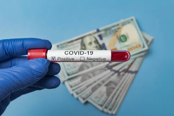 手にCovid 19の血液検査 接近中だ 背景にあるお金 — ストック写真