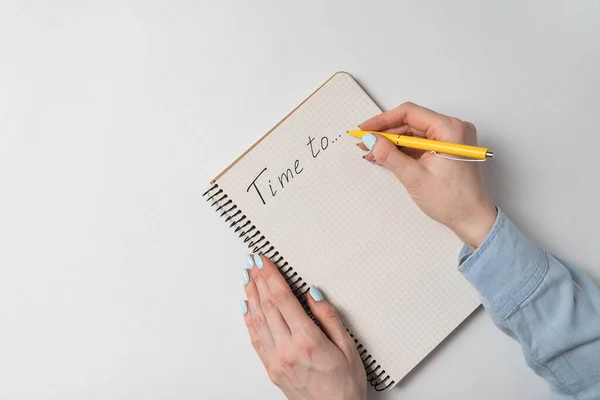 メモ帳に白い背景で通知する時間 手書きの言葉 女性の手と白い背景のノート — ストック写真