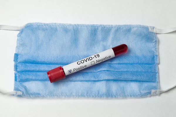 Test tubes with analyze blood on coronavirus, surgical mask to cover the mouth and nose.