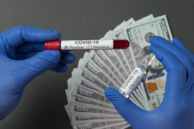 Doktor Coronavirus için pozitif kan testi ve Covid-19 için de bir şişe aşı tutuyor. Tedavi için fiyat, tıbbi eldivenler..