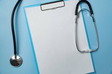 Steteskop ve mavi arka plandaki belgeler. Mesajın için boş kağıtlar. Uzayı kopyala. Model.