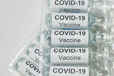 Beyaz arka planda Covid-19 etiketli Ampuller. Coronavirüs gribi tedavisi.