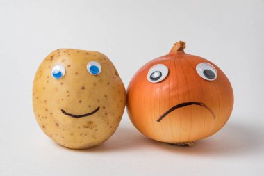 Pozitif patates ve beyaz arka planda pörtlek gözlü üzgün bir Napiform soğanı. Kötümser ve iyimser kavram