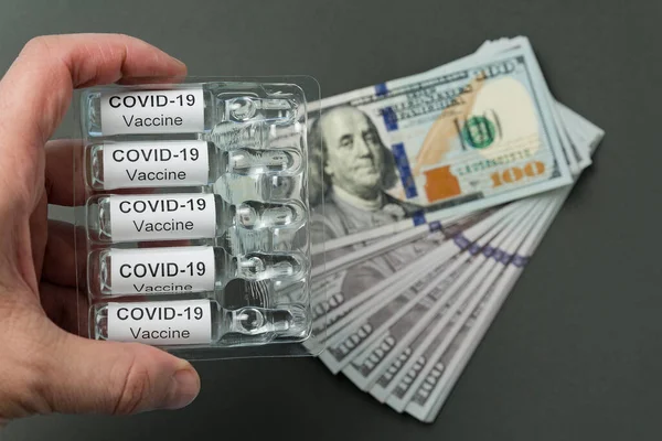 お金の背景にコロナウイルスや注射器のためのワクチンとアンプル Covid 19からの薬のコスト — ストック写真