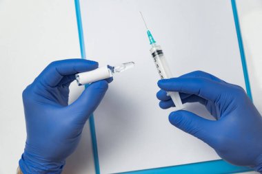 Tıbbi eldivenli doktor elinde şırınga ve ilaç şişesi tutuyor. boş etiket. Uzayı kopyala Model.