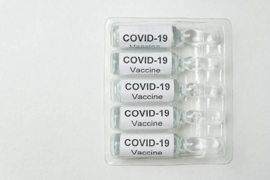 2019-NCov aşısı olan ampuller. Beyaz arkaplanda Covid-19 etiketli şişeler