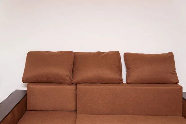 Brown corner sofa with large cushions. Upholstered furniture.