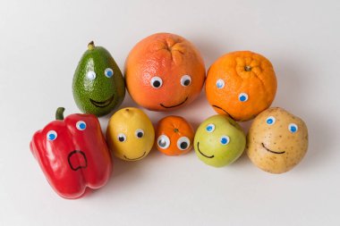 Sebzeler, meyveli karakterler, şaşı gözler ve komik suratlar. Uygun beslenme kavramı.