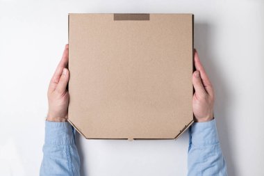 Erkek elleri ve beyaz arka planda bir kutu pizza. Eve yiyecek teslimatı kavramı.