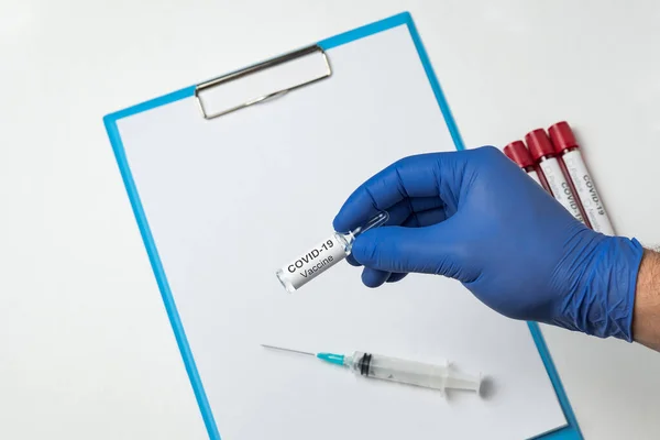 Lekarz Trzyma Fiolkę Koronawirusem Szczepionkowym Tle Strzykawki Czystej Kartki Papieru — Zdjęcie stockowe