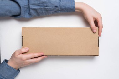 Çocuk beyaz arka planda dikdörtgen el işi kağıt kutu tutuyor. Paket teslimat konsepti. Üst görünüm