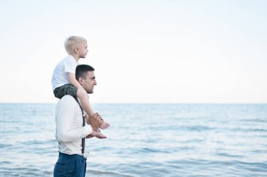 Oğlu babasının omuzlarında oturuyor. Büyük ve küçük kardeş. Erkek yaşı kavramı.