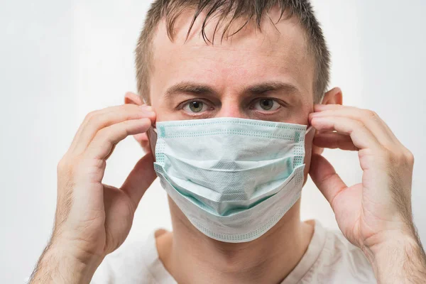 Tired doctor in protective face mask prevent virus infection. Portrait close up.