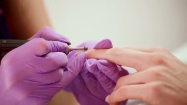 Profesyonel donanım manikürü sırasında elektrikli makine kullanarak manikür ustası. SPA salonunda prosedür.