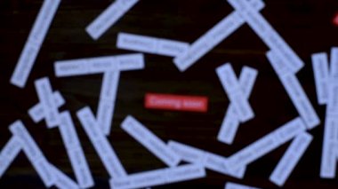 Büyüteçle el, yakında gelecek cümleye odaklanıyor. Çözüm bulmak. Koyu tahta masada etiket bulutu.