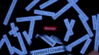 Büyüteçle el, mesaj cümlesine odaklanır. Çözüm bulmak. Koyu tahta masada etiket bulutu.