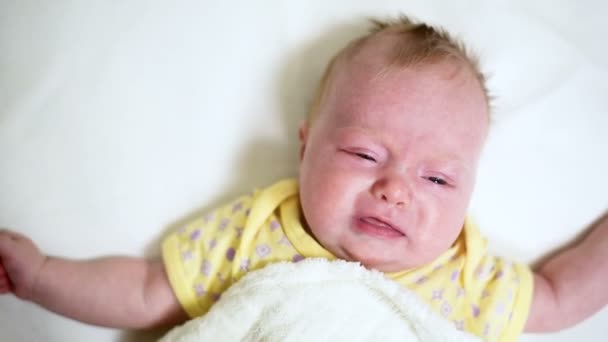 哭泣的金发婴儿躺在一张白色的床上 靠近点 — 图库视频影像
