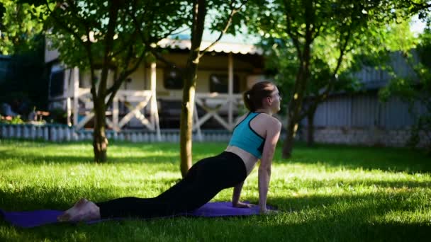 Zwangere vrouw in de tuin beoefent yoga. Zomer ochtend. — Stockvideo